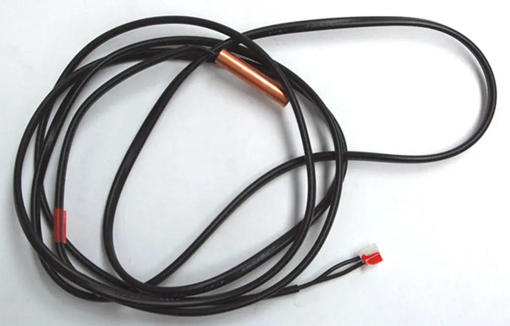 Daikin Fühler mit zwei schwarzen Kabeln, einem roten Stecker und einem metallischen Element in der Mitte. Das Kabel ist aufgewickelt und auf einem weißen Hintergrund.